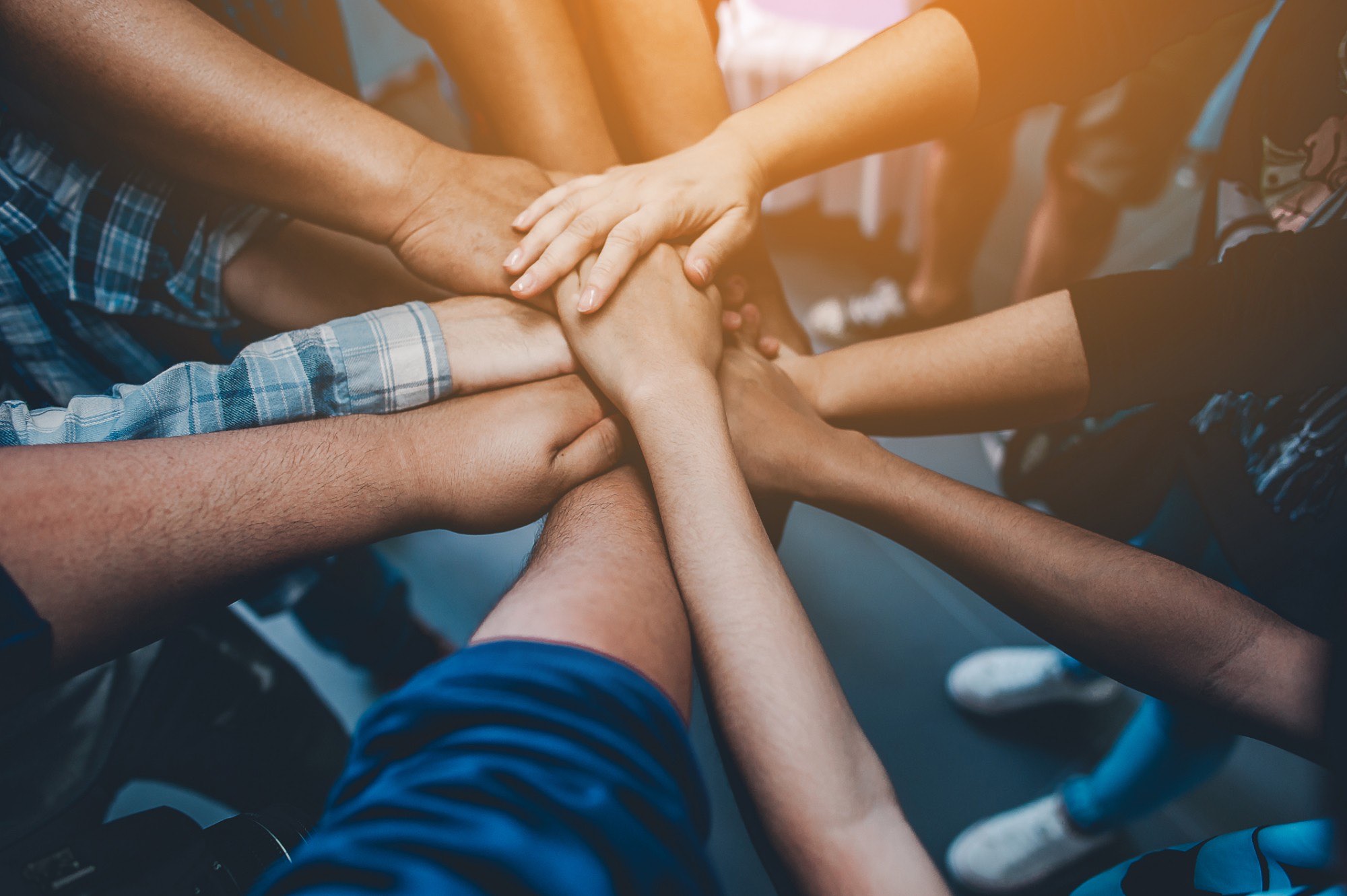 A group of people stacking their hands together in the middle